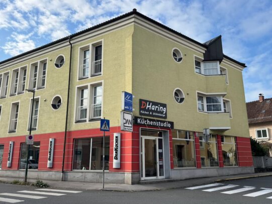 Ansicht von außen auf das D.Haring Küchenstudio in Oberndorf bei Salzburg - rote Fassade mit großen Glasfronten.