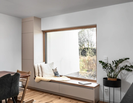 Maßgefertigte Sitzbank am Fenster in den Fronten Jasmin mit viel Stauraum und angrenzendem Hochschrank.